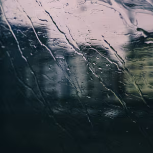 Between Stops Three photographs taken through a rain-streaked train window, where blurred city lights and shifting tones explore...